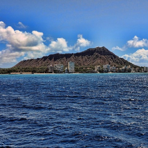 a large body of water with a mountain in the background