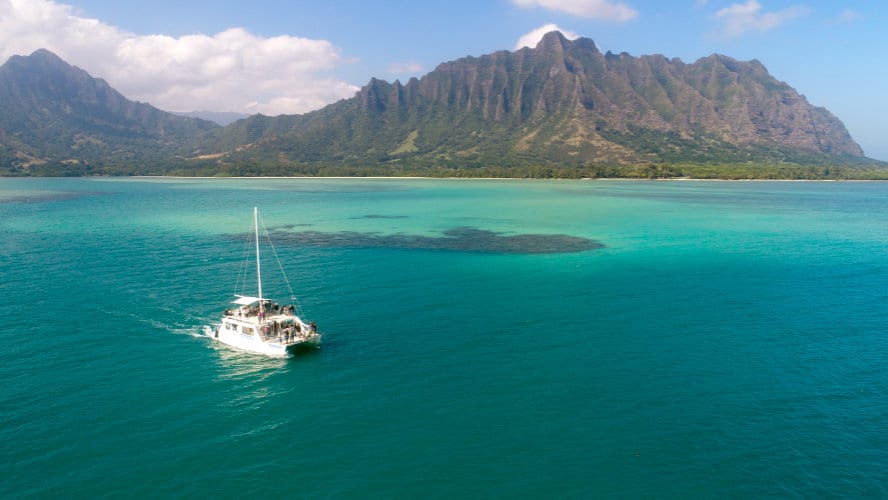 a small boat in a body of water with a mountain in the background