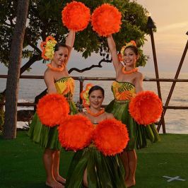 a group of people sitting at a table with a vase of flowers