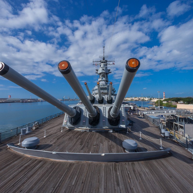 a large ship in the background with USS Missouri (BB-63) in the background