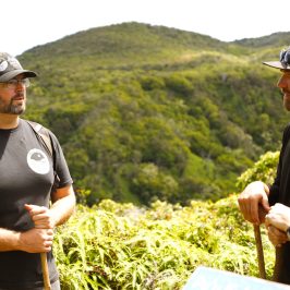 a man and a woman standing in front of a mountain
