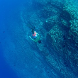 a man swimming in blue water