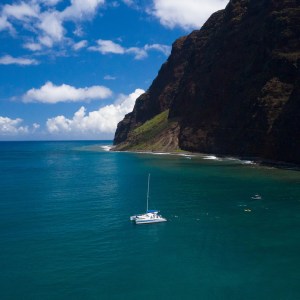 a small boat in a body of water with a mountain in the background