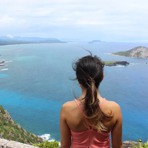 a woman standing in front of a body of water