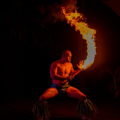 a man sitting at a fire in the dark