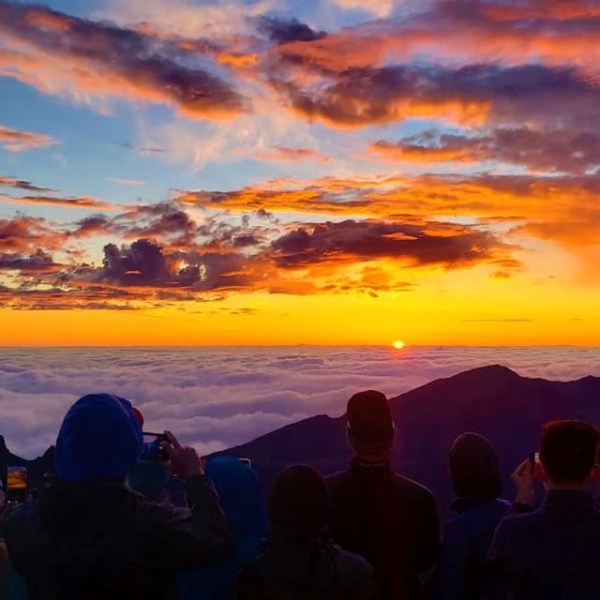 a group of people walking through a cloudy sky