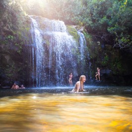 a group of people standing next to a waterfall