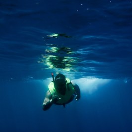 a man flying through the air while swimming in a body of water