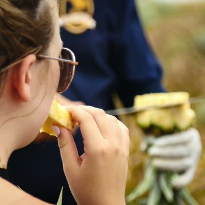 a woman wearing glasses eating a hot dog
