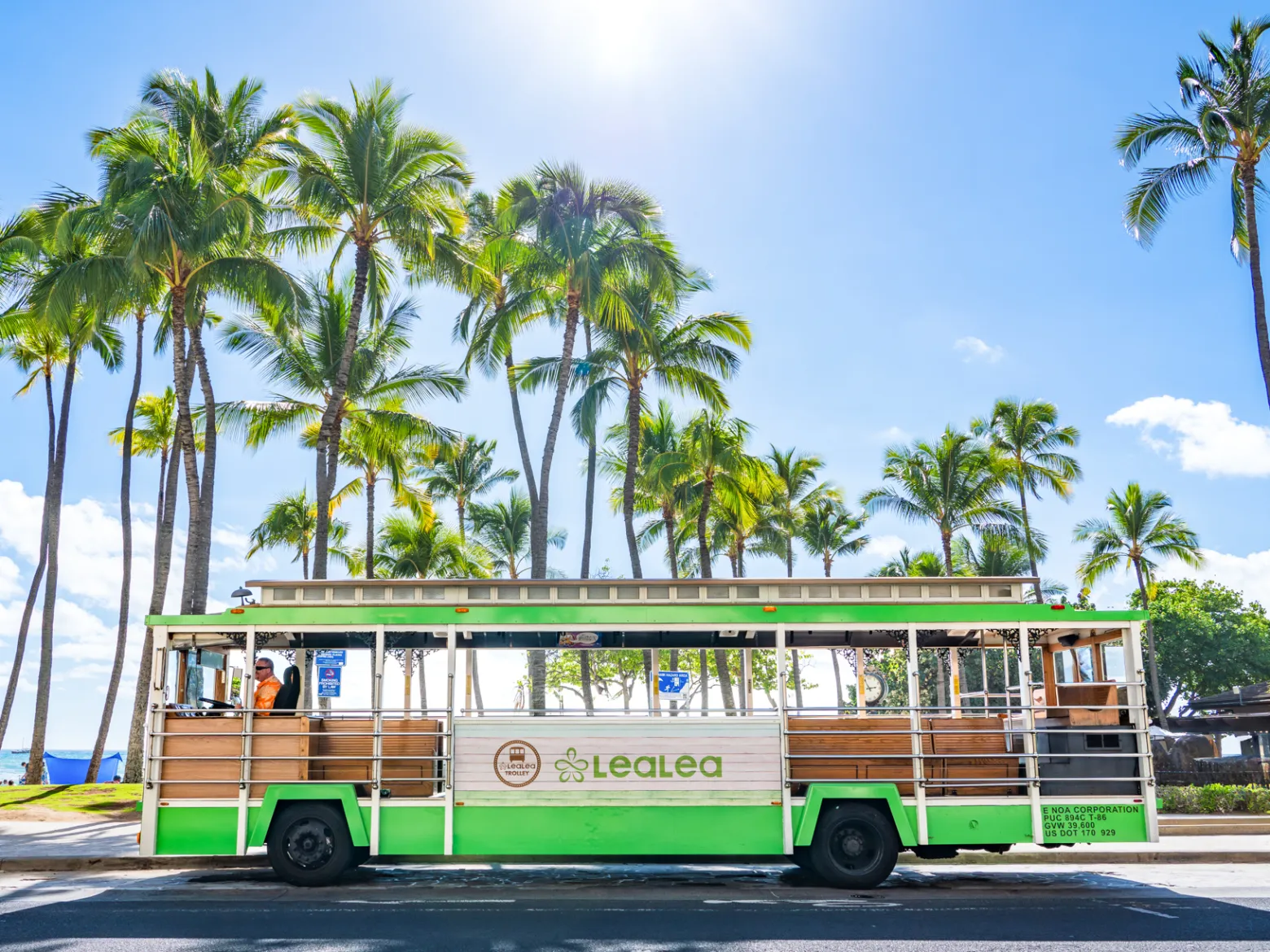 a bus parked in front of a palm tree LeaLea Trolley - Hop-on hop-off Trolley in Waikiki and beyond! Explore Oahu! The Light Green Colored Trolley are usually to/from Waikiki and Ala Moana (shoppint Shuttle)
