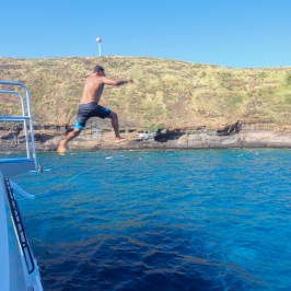 a man riding on the back of a boat in the water