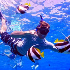 a person flying through the air while swimming in a body of water