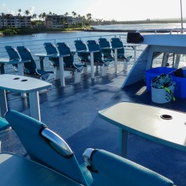 a group of people sitting at a table with a blue umbrella