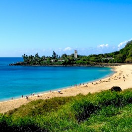 a sandy beach next to a body of water