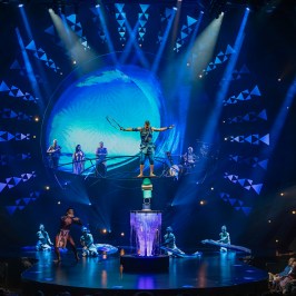 a person on stage with stage lights and an audience