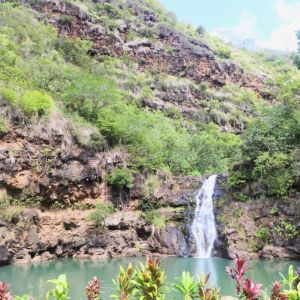 a group of people standing next to a waterfall