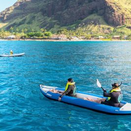 a group of people riding on the back of a boat in the water