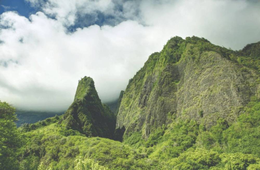 Lush green mountains under a cloudy sky.